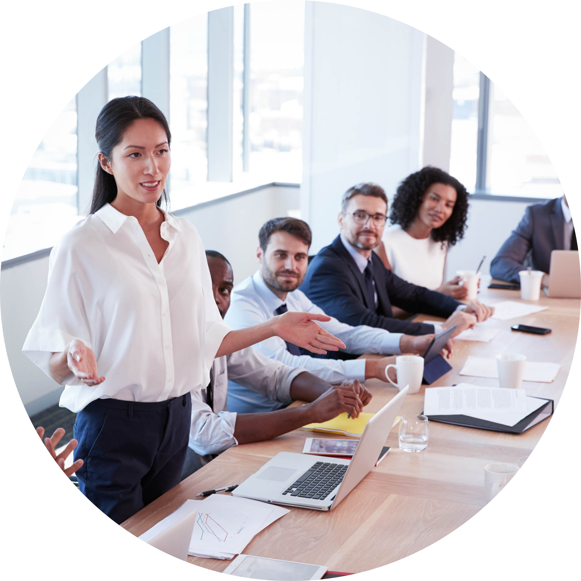 Business-005-Businesswoman-Stands-To-Address-Meeting-Around-Board-Table-circle.png